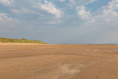 Güneşli bir yaz gününde Formby, Merseyside 'daki engin kumlu plaja bakıyorum.