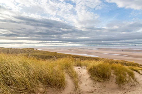 Looking out over marram grass covered sand dunes towards the sea, at Formby in Merseyside