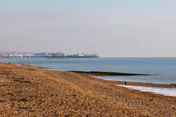 Hove 'daki boş sahil boyunca Brighton Rıhtımı' na doğru kış boyunca bakıyorum.