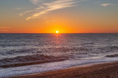 Güneş Brighton Sahili 'nde denizin üzerinde batıyor.