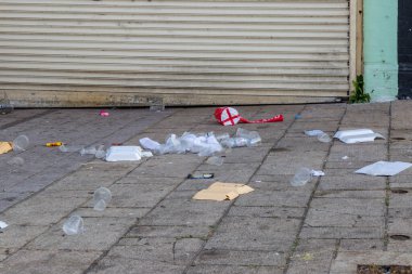 Boş yiyecek ve içecek ambalajı kaldırımda.