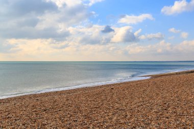 Sakin deniz ve Brighton, Sussex 'teki çakıl taşı plajı.