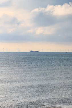 Ufukta, Sussex, Brighton 'da bir rüzgâr çiftliği ve gemi görünüyor..