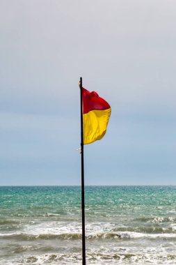 Sahilde kırmızı ve sarı uyarı bayrağı
