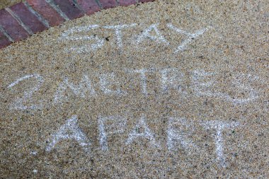 Covid-19 salgını sırasında kaldırımda bir uyarı işareti.