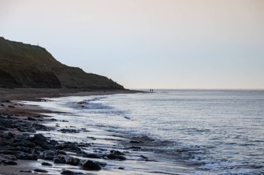 Güneşin doğuşundan hemen sonra Wight Adası 'ndaki bir plaja bakıyorum.