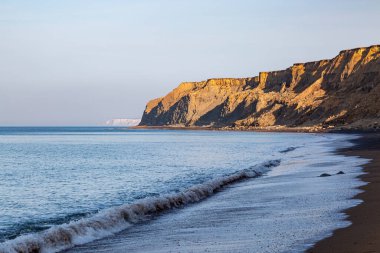 Güneşli bir yaz sabahında Wight adasının engebeli sahil şeridine bakıyorum.