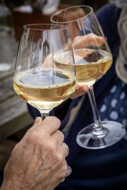 A close up of wine glasses being held for a toast