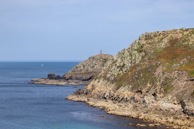 Güneşli bir yaz gününde, Cornwall Burnu 'na doğru engebeli sahil şeridine bakıyorum.