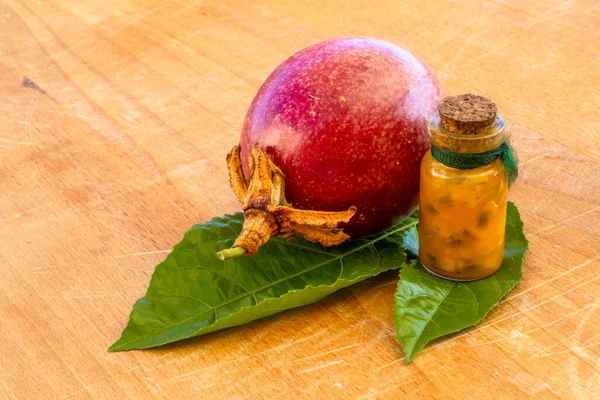 マラクージャは瓶とフラスコの半分に切り 木の背景に葉で全体を切りました フルーツジュースと種のパッションフルーツ — ストック写真