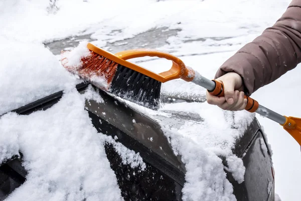 女性が雪の中から車をブラシ クローズ アップ — ストック写真