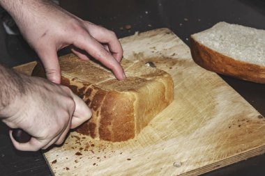 Adam ekmek parçaları yakın çekim içine keser