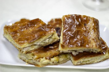 Pasta beyaz bir plaka üzerinde büyük parçalar halinde kesilmiş