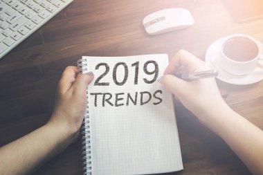 Yazıt 2019 eğilimleri bir tanıtıcı ve bir fincan kahve ile ahşap bir masaya yatıyor bir defter