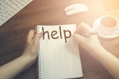 Bir fincan kahve yanında ahşap bir masa üzerinde yatıyor bir defter yazıt yardım yapılan kadın