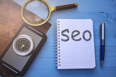 Eski tablo harita ve pusula yanında bir not defteri ile Seo metin açıktır