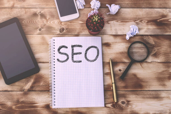 Notepad with the inscription SEO is on a wooden table with a handle and appliances