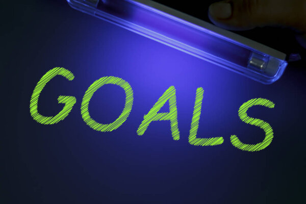 The word GOALS is manifested under the ultraviolet lamp in green