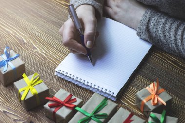 Ahşap bir masa üzerinde Önden Görünüm yatıyor bir defter bir not bir kadın yapar