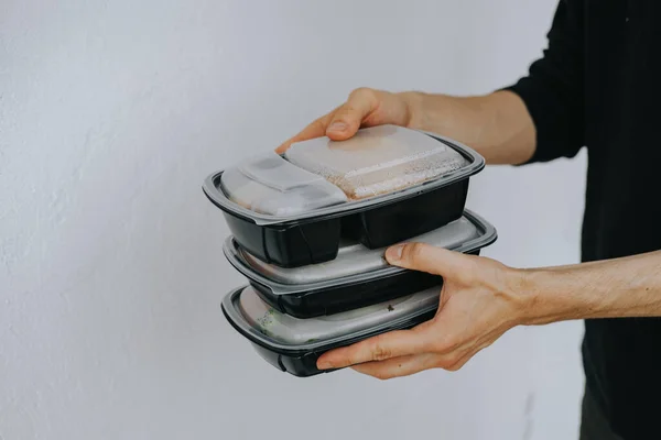 Food delivery. Man holds disposable food containers