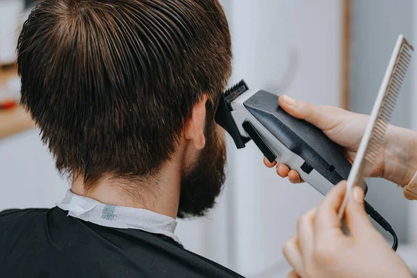 Fryzura męska w domu. Fryzjer obcina włosy mężczyźnie. — Zdjęcie stockowe