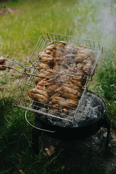 O processo de preparação de asas de frango grelhadas. Piquenique ao ar livre . — Fotografia de Stock
