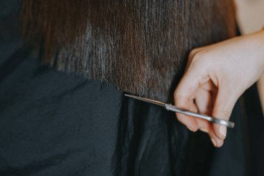 Evde kadın tıraşı. Kuaför evde bir kızı kesiyor..