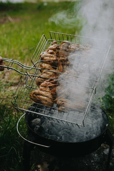 Il processo di preparazione delle ali di pollo alla griglia. Picnic all'aria aperta. — Foto Stock