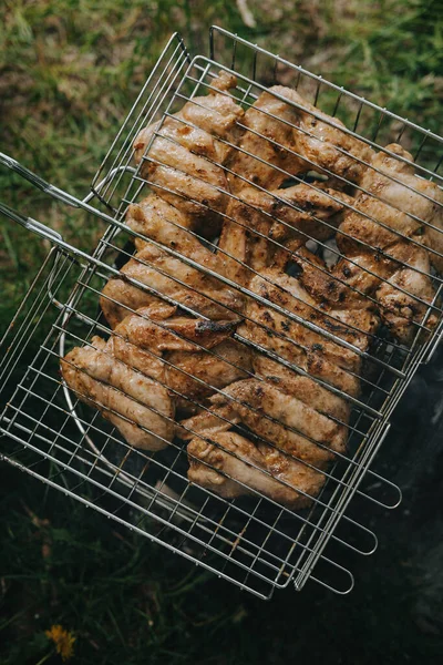 O processo de preparação de asas de frango grelhadas. Piquenique ao ar livre . — Fotografia de Stock