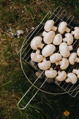 Izgarada şampiyon mantarları pişiriyorum. Açık hava pikniği