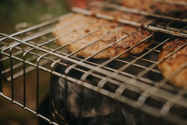 Il processo di preparazione di cotolette di carne per hamburger alla griglia. Picnic all'aria aperta — Foto Stock