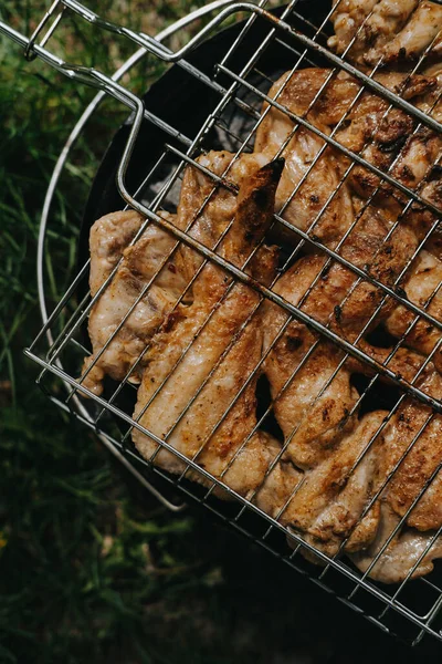 Proces přípravy grilovaných kuřecích křidélek. Piknik na čerstvém vzduchu. — Stock fotografie