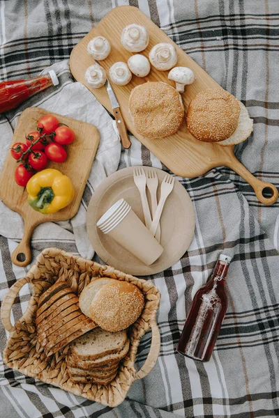 Friss piknik egy kockás ételen. Paprika, paradicsom, saláta, kenyér. Kézműves lap, szemüveg és fából készült villa — Stock Fotó