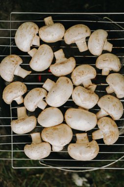 Izgarada şampiyon mantarları pişiriyorum. Açık hava pikniği