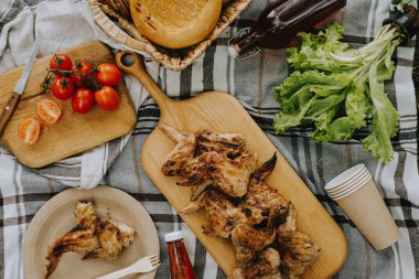 Kesme tahtasında ızgara tavuk kanadı. Açık hava pikniği