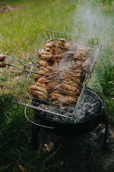 O processo de preparação de asas de frango grelhadas. Piquenique ao ar livre . — Fotografia de Stock