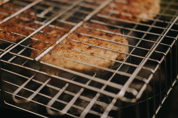 O processo de preparação de costeletas de carne para hambúrgueres grelhados. Piquenique ao ar livre — Fotografia de Stock