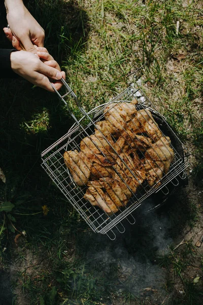 O processo de preparação de asas de frango grelhadas. Piquenique ao ar livre . — Fotografia de Stock