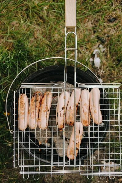 Salsicce di carne alla griglia su una griglia. Picnic all'aria aperta — Foto Stock