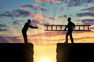 Bir adam silüeti uçurumun diğer tarafında başka bir adam bir merdiven taşır. Ekip çalışması ve karşılıklı yardım kavramı