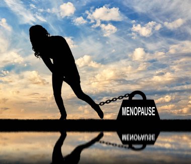 Üzgün bir kadın silueti ve menopoz ağır bir yük bacağı için zincirli. Menopoz kadınlarda kavramsal görüntü