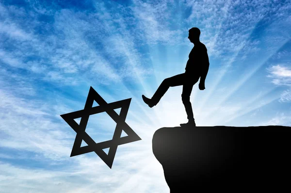 Man atheist pushes the symbol of Judaism into the abyss — Stock Photo, Image