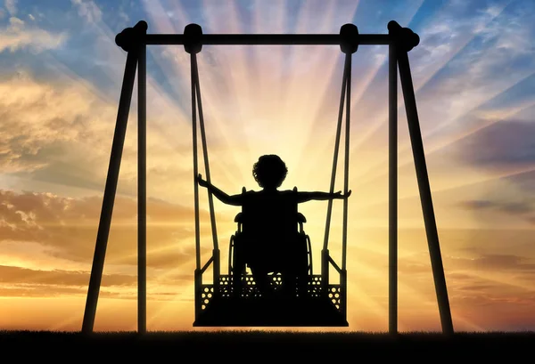 Happy child is disabled in a wheelchair on an adaptive swing for disabled children — Stock Photo, Image