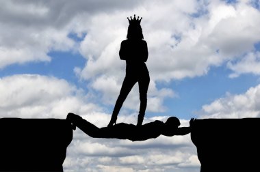 Selfish woman with a crown standing on a man in the form of a bridge over an abyss clipart