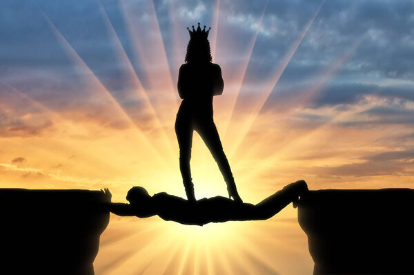 Selfish woman with a crown standing on a man in the form of a bridge over an abyss