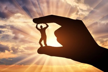 İşyeri zorbalığı. Bir elin silueti bir adamın parmaklarının arasında.