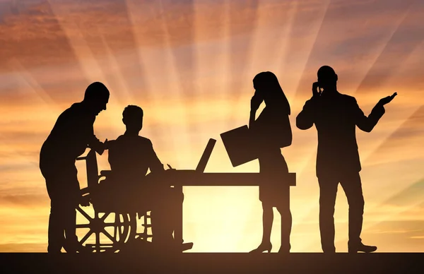 Deficiente a trabalhar. Silhueta de um deficiente em uma cadeira de rodas e sua equipe de trabalho — Fotografia de Stock