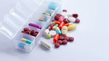 Her gün ilaç kutusu al, ilaçlarla, haplarla ve kapsüllerle dolu bir ilaç. İlaçlar tedavi ve hastalığın tedavisi için kullanılır. Tıbbi klinikteki ilaçlar beyaz arka planda izole edilmiş, kopyalama alanı var.