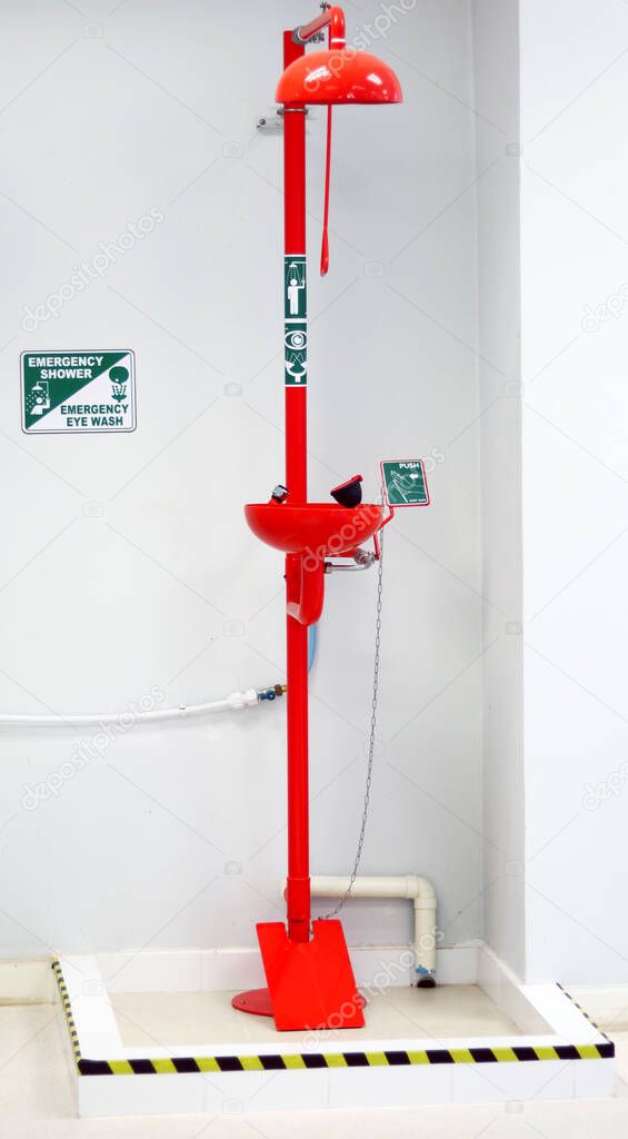 Emergency shower and Eye wash station for washing eyes, when touch with Acid or toxic chemical, safety first protection equipment in chemistry laboratory with black-yellow stripes for warning steps.