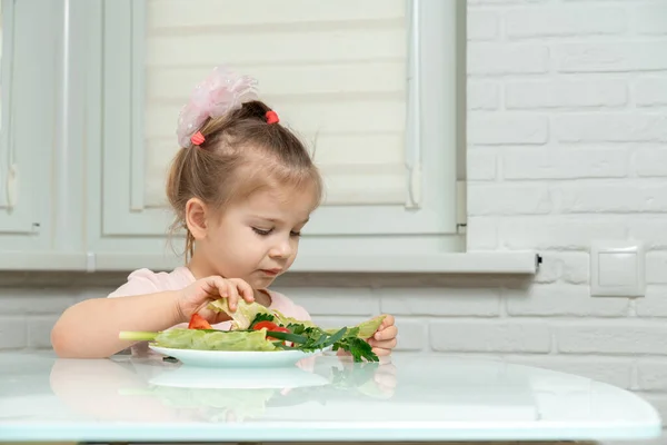 little girl 3-5 years old eats vegetables. White background
